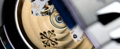 Sapphire caseback of a steel Patek Philippe Nautilus showing the gold rotor with the Calatrava cross