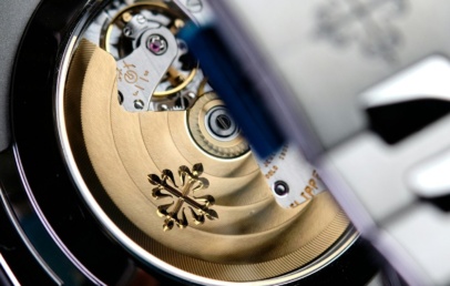Sapphire caseback of a steel Patek Philippe Nautilus showing the gold rotor with the Calatrava cross