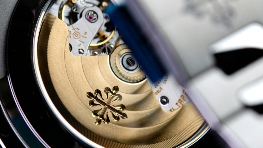 Sapphire caseback of a steel Patek Philippe Nautilus showing the gold rotor with the Calatrava cross