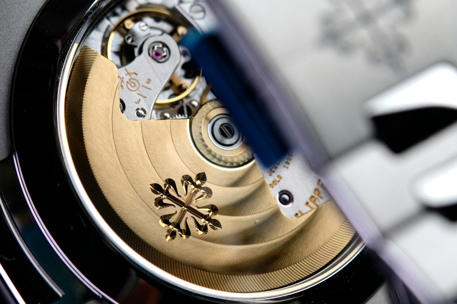 Sapphire caseback of a steel Patek Philippe Nautilus showing the gold rotor with the Calatrava cross