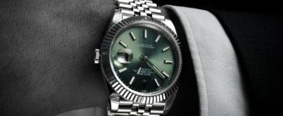 Steel Rolex Datejust 41 with green dial, fluted bezel and jubilee bracelet, on the wrist with a suit cuff
