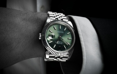Steel Rolex Datejust 41 with green dial, fluted bezel and jubilee bracelet, on the wrist with a suit cuff