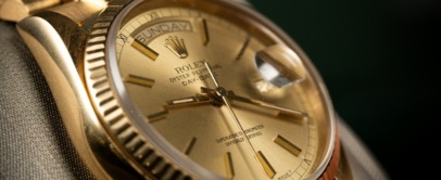 Yellow gold Rolex Day-Date with champagne dial and fluted bezel on a President bracelet, on a display cushion