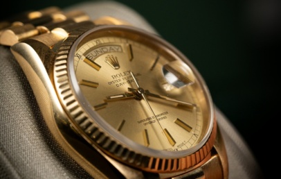Yellow gold Rolex Day-Date with champagne dial and fluted bezel on a President bracelet, on a display cushion