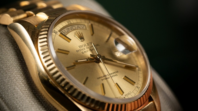 Yellow gold Rolex Day-Date with champagne dial and fluted bezel on a President bracelet, on a display cushion