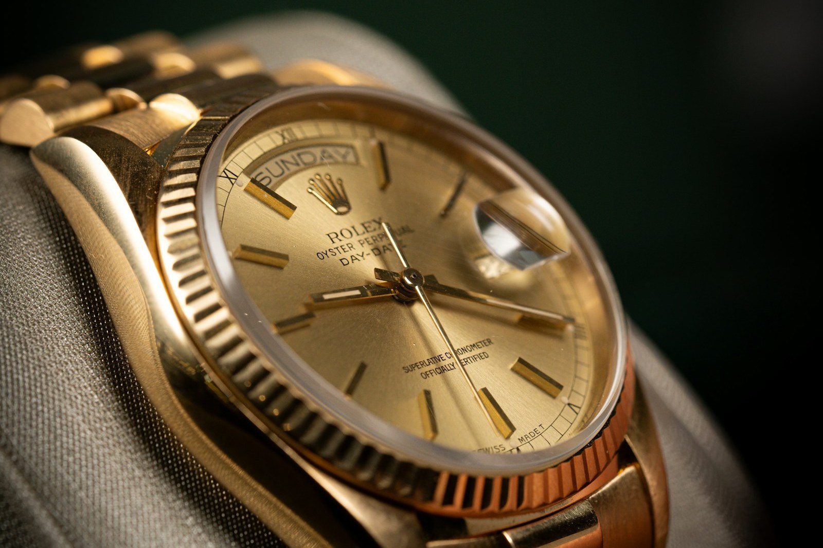 Yellow gold Rolex Day-Date with champagne dial and fluted bezel on a President bracelet, on a display cushion