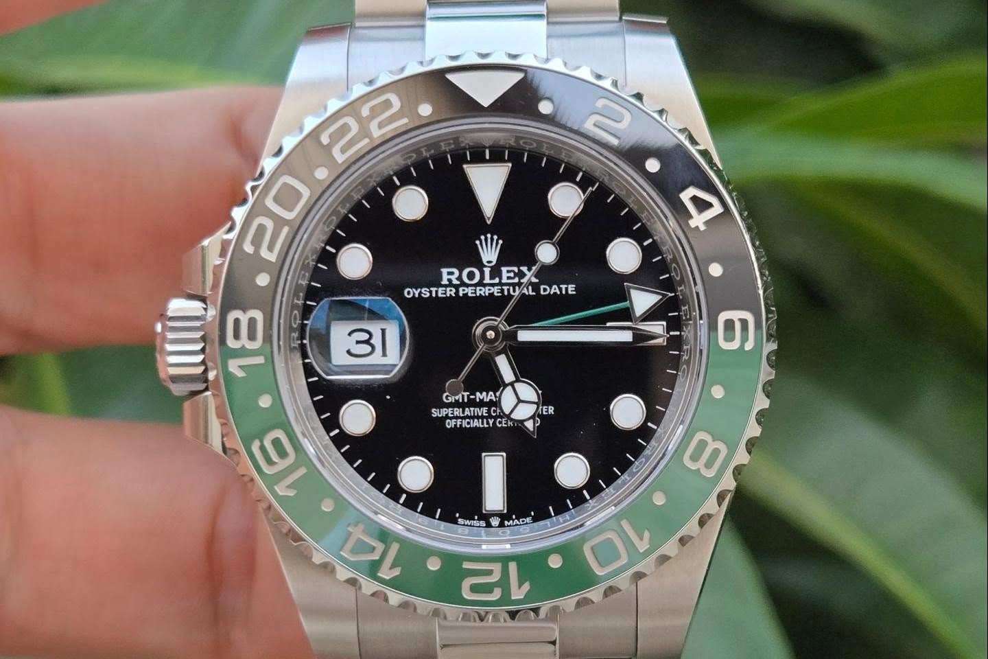 Steel Rolex GMT-Master II Sprite 126720VTNR with green and black bezel and left-side crown, held in hand