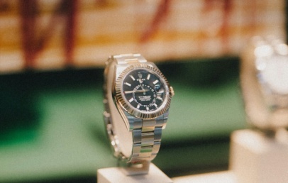 Rolex Sky-Dweller with black dial and fluted bezel on an Oyster bracelet, on a display stand