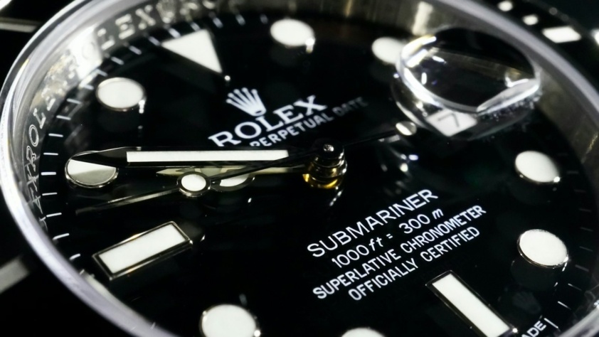 Close-up of a black Rolex Submariner Date dial and ceramic bezel