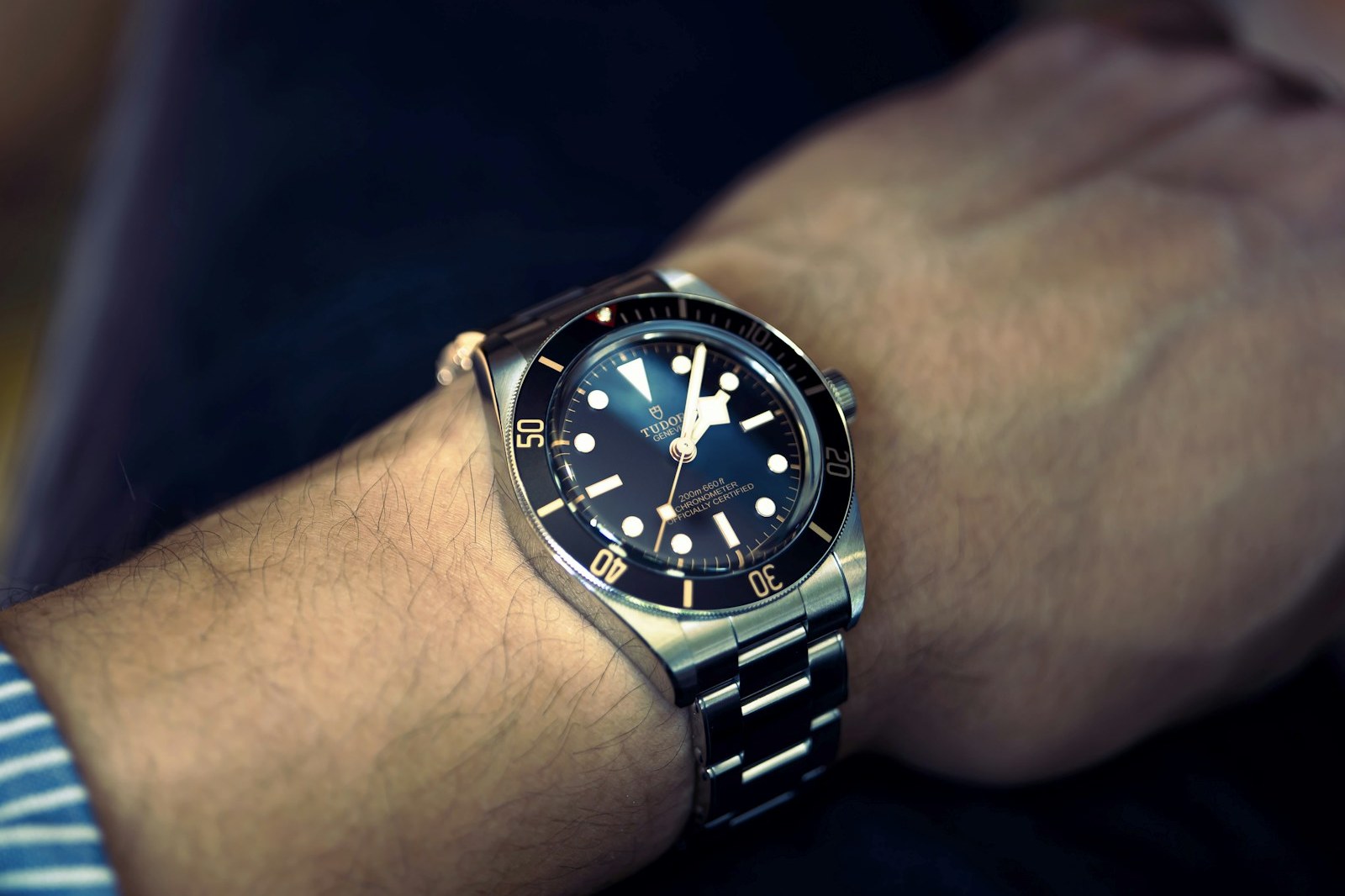 Tudor Black Bay with black dial and gilt bezel markings on a steel bracelet, on the wrist